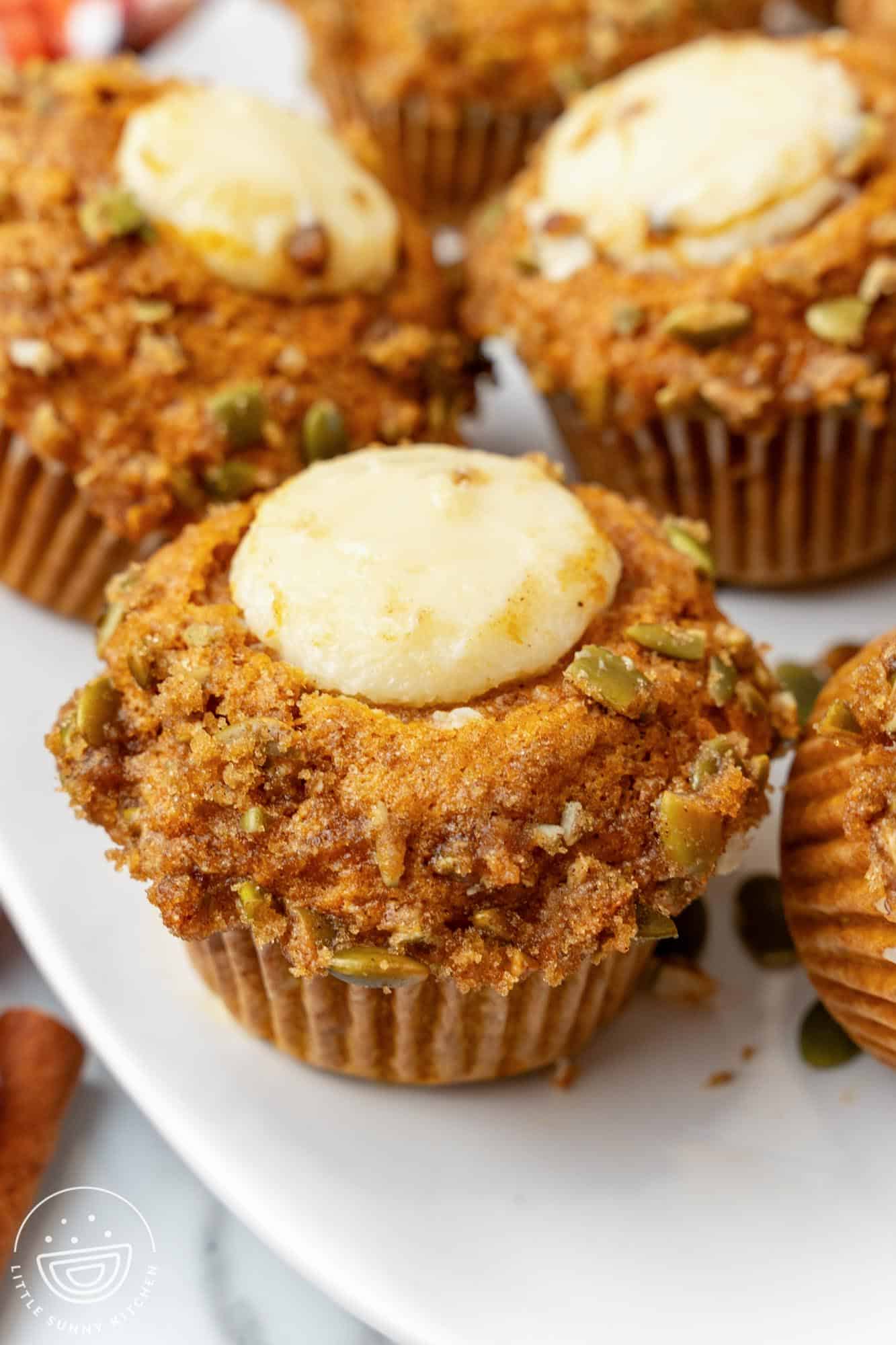 closeup of a homemade starbucks pumpkin cream cheese muffin on a platter.