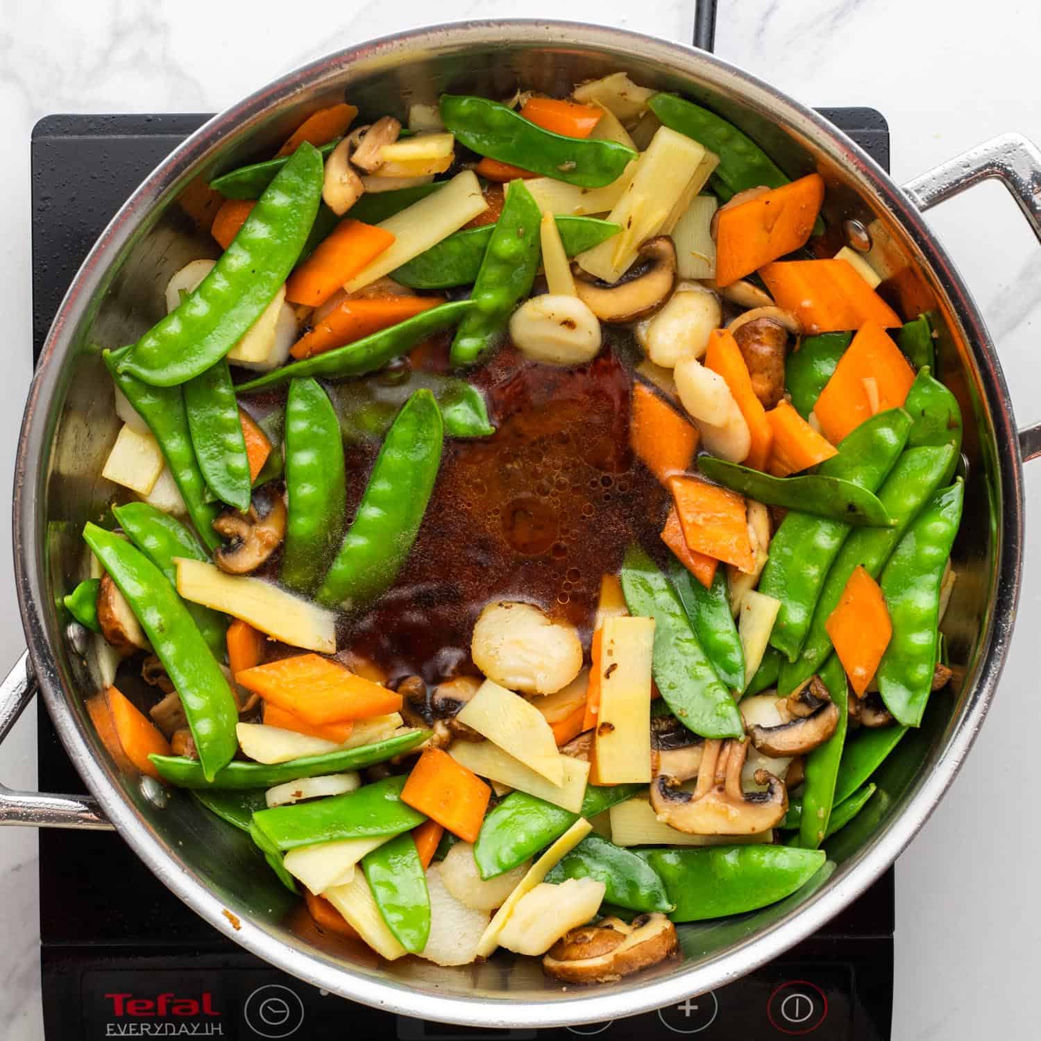 broth and soy sauce added to vegetable stir fry.