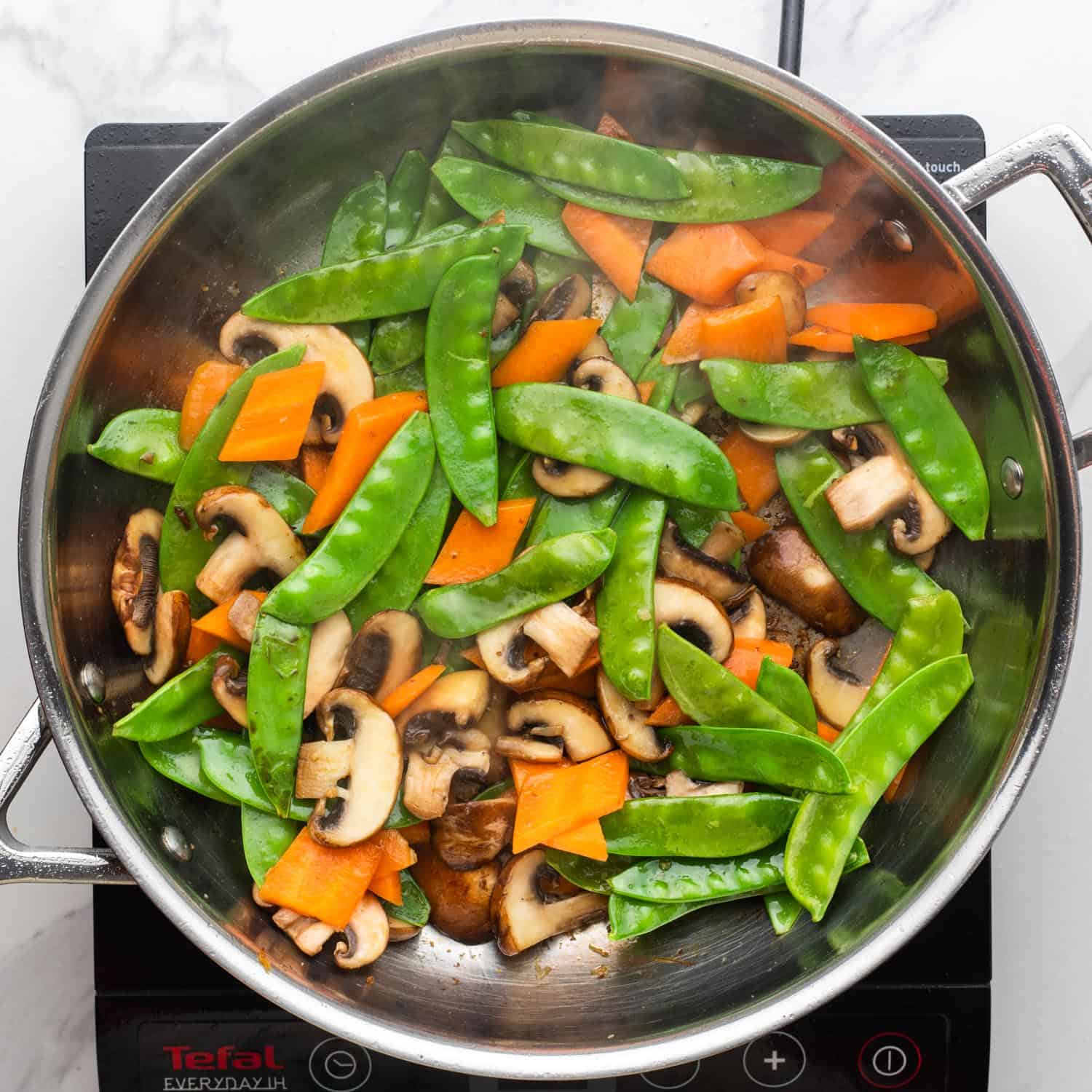 sauteed mushrooms with carrots and snow peas.